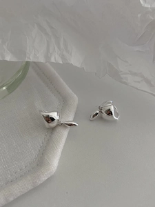 Detailed close-up of polished S925 sterling silver waterdrop earrings on white fabric