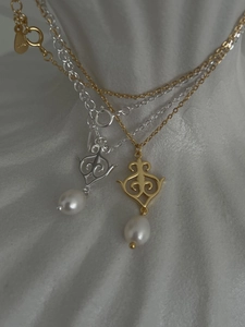 Macro detail of S925 silver and gold pearl pendants with intricate hollow carvings