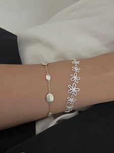 Detail of S925 silver hollow daisy flower bracelets showing brushed metal texture and shine