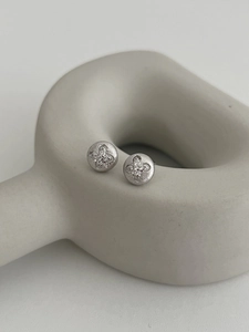 Macro view of S925 sterling silver four-leaf clover stud earring with brushed finish
