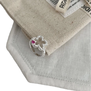 Sweet S925 silver flower ring with a pink heart gemstone on a beige canvas background