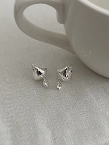 Detailed view of polished S925 sterling silver waterdrop earrings on white linen fabric