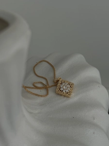 Detailed view of vintage gold hollow pendant necklace with sparkling crystal flower center