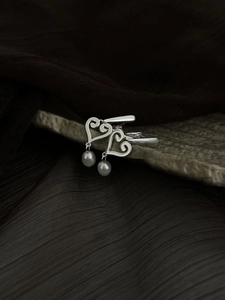 Détail de boucles d'oreilles cœur en argent S925 avec perles d'eau douce blanches