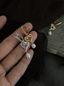 Détail de boucles d'oreilles cœur en argent S925 avec perles d'eau douce dorées et argentées