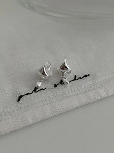 Detail view of S925 sterling silver teardrop earrings on white textured linen cloth