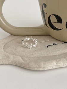 Vue détaillée d'une bague papillon en argent ajouré sur un dessous-de-verre en lin crème