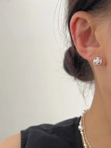Detailed close-up of S925 sterling silver four-leaf clover stud earring with sparkling accents