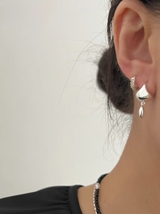 Close-up of S925 sterling silver hoop earrings with shimmering crystals and teardrop charm