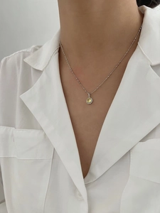 Gros plan d'un collier en argent S925 avec un pendentif en pierre jaune éclatante