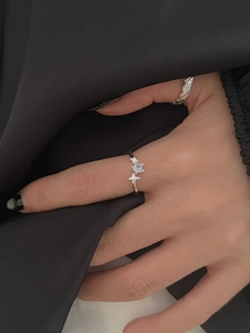 Detail of S925 silver ring featuring asymmetric stars and clear zircon on a model hand
