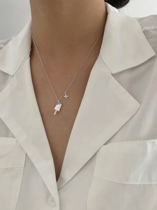Close-up of S925 silver popsicle pendant with blue diamonds on a model wearing white shirt
