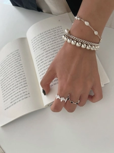 Vue rapprochée de la bague papillon en argent S925 et des bracelets sur une main