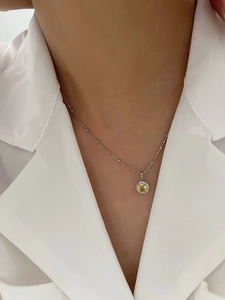 Gros plan d'un collier en argent S925 avec pendentif en pierre jaune sur un mannequin femme