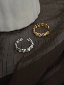 Vue détaillée des bagues en argent sterling S925 doré et argenté sur tissu sombre plissé