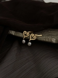 Vue détaillée de boucles d'oreilles cœur en filigrane doré avec perles d'eau douce