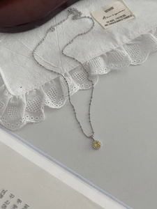 Détail macro du collier en argent S925 avec pendentif cristal jaune sur dentelle