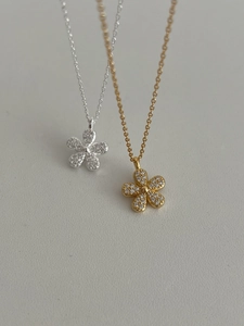 Detail of silver and gold flower necklaces with full pavé cubic zirconia petals