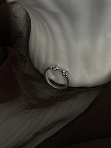 Macro detail of vintage silver open ring featuring ornate cross flower relief carving