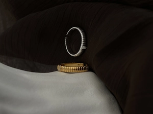 Macro shot of minimalist textured band ring with diamond accents in gold and silver finish