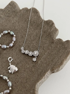 Detail of S925 sterling silver stamp on micro-pave floral pendant and pearl necklace