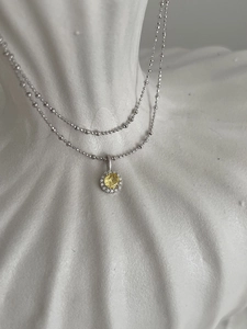 Macro de collier en argent S925 avec pendentif halo serti d'une pierre jaune facettée