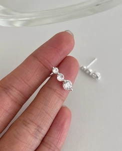Detailed close-up of S925 silver stud earrings with three graduated zircon stones