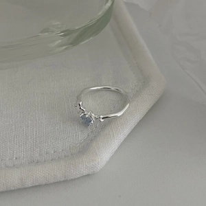 Minimalist S925 sterling silver adjustable star ring with blue gemstone on white fabric