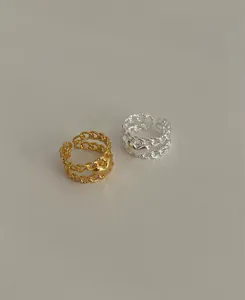 Detailed macro view of gold and silver heart charm chain rings with adjustable bands
