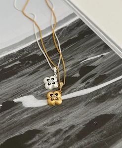 Macro di ciondoli a fiore a quattro petali in oro e argento con trama opaca spazzolata e gemma