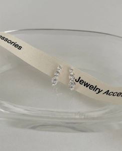 Macro view of S925 silver stud earrings with three vertical sparkling zircon stones