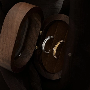 Elegant silver and gold spiral rings with pavé diamonds in a premium wooden box