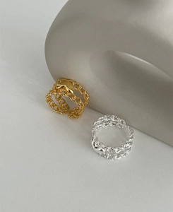 Close-up of heart-shaped gold and silver chain link rings with polished mirror finish