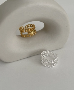 Detail of silver and gold heart rings featuring layered chain design and open adjustable band