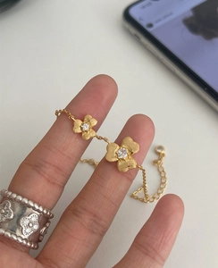 Detail of 18K gold-plated clover bracelet with brushed texture and zircon inlay