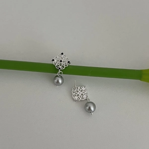 Silver镂空 floral earrings with gray pearl drops and black crystals on light background