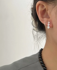Detail of S925 silver ear cuff with braided texture and three-stone zircon stud earrings