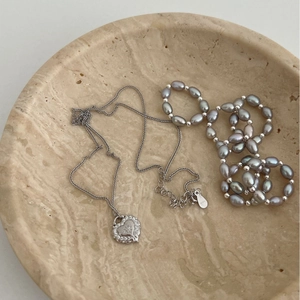 Collana in argento 925 con cuore spazzolato e perle barocche su vassoio in pietra