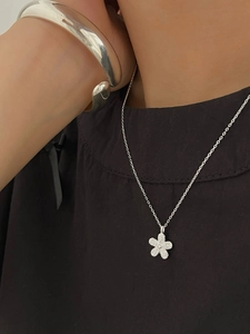 Macro detail of 925 sterling silver flower necklace with micro-pave diamond petals