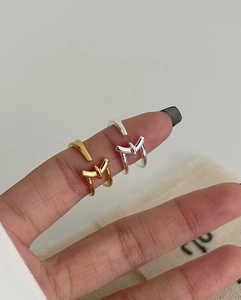 Detail of minimalist S925 sterling silver knotted open rings in gold and silver finish