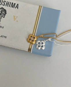 Dettaglio di ciondoli a quadrifoglio in argento S925 con texture spazzolata e cristalli