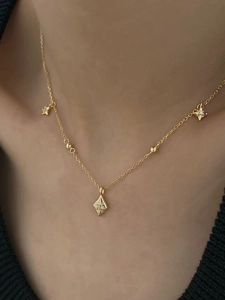 Détail du collier étoile en argent 925 doré avec centre en diamant et chaîne à perles
