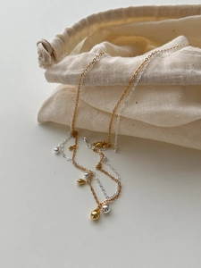 Minimalist silver and gold teardrop pendant necklaces with a linen storage pouch