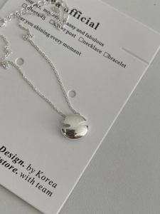 Détail macro du pendentif en V en argent sterling S925 avec une finition miroir polie