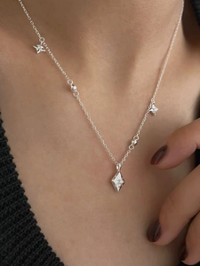 Détail d'un collier étoile en argent sterling 925 porté sur un pull en maille