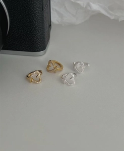 Detail view of gold and silver heart-shaped hoop earrings with shimmering pave zircon stones