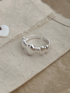 Macro shot of silver bubble ring with adjustable open design on rustic linen background