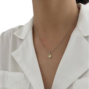 Élégant collier en argent sterling S925 avec pendentif rond jaune porté par un modèle