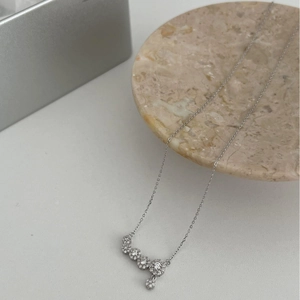 Sparkling S925 silver necklace with curved zircon pendant on a marble display