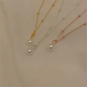 Detailed view of three elegant S925 silver necklaces with pearls in gold, silver, and rose gold